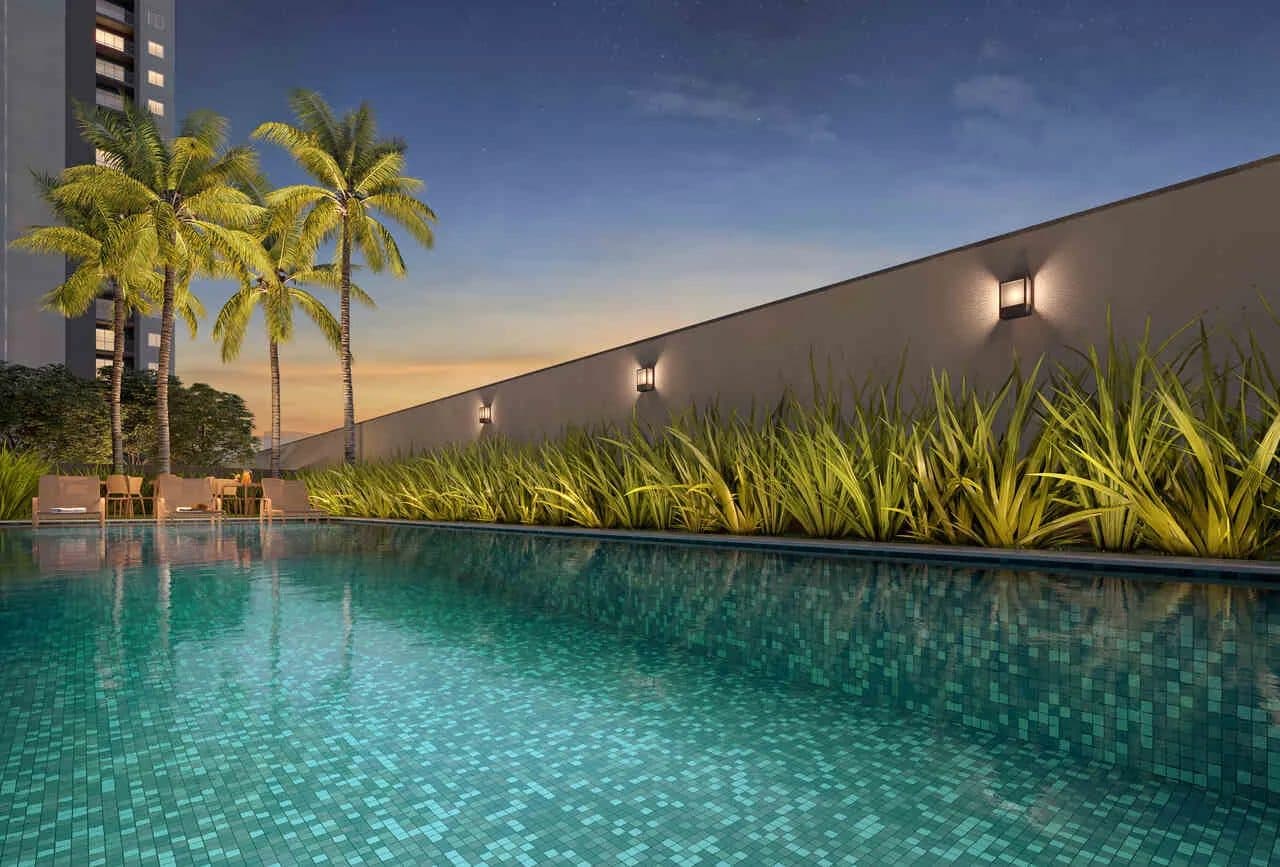 Piscina do condominio cercada por palmeiras e espreguiçadeiras.